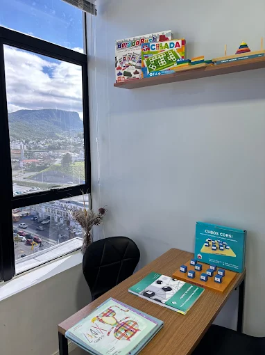 Sala de espera da AMI com sofá claro e parede rosada